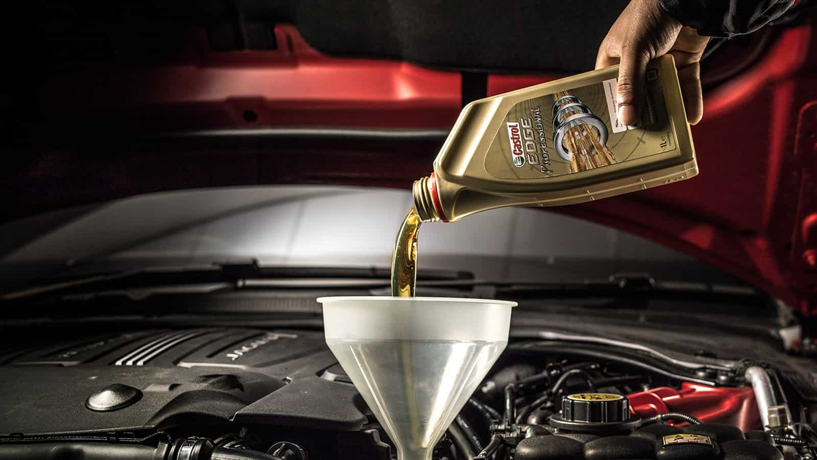 A bottle of Castrol EDGE professional oil being pored into a Jaguar engine.